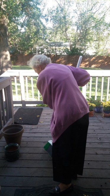mom-sweeping-acorns-on-back-deck-oct-2016